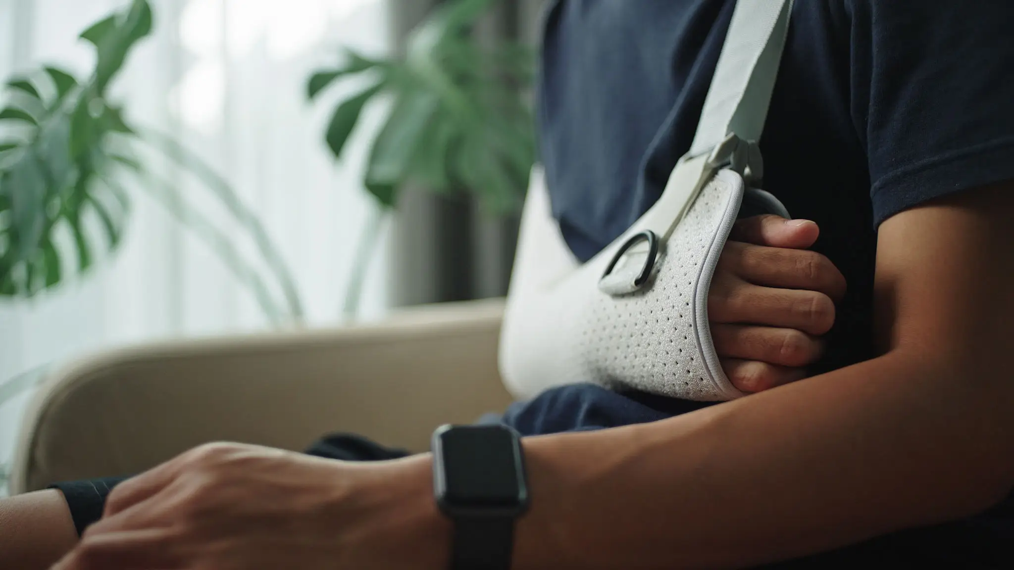 Person with arm sling and smartwatch