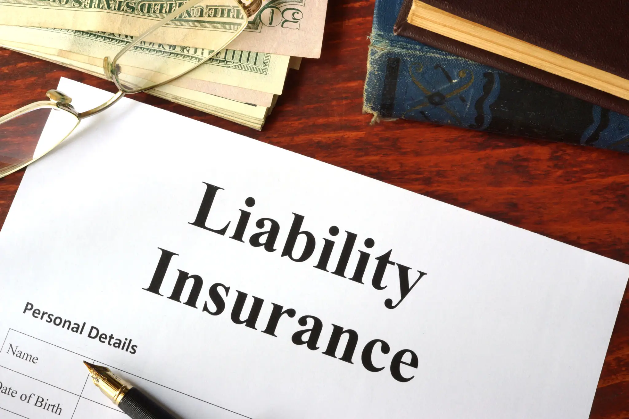 Liability insurance document with pen and glasses