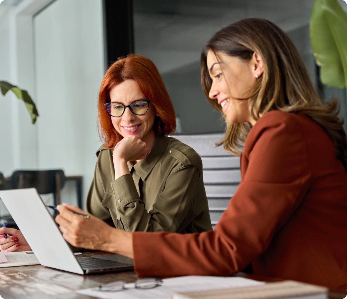 Women discussing work at a desk
