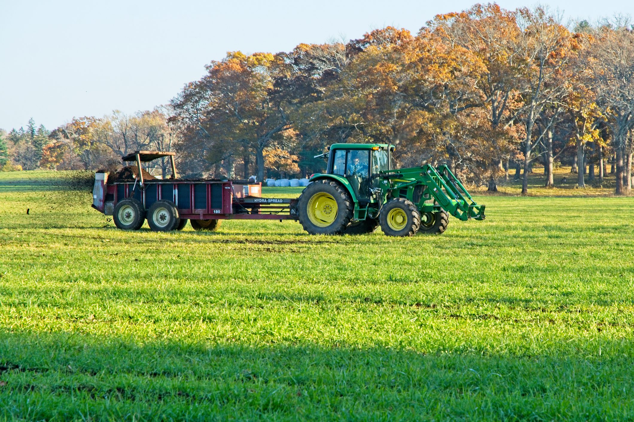 Tractor spreading fertilizer on a field