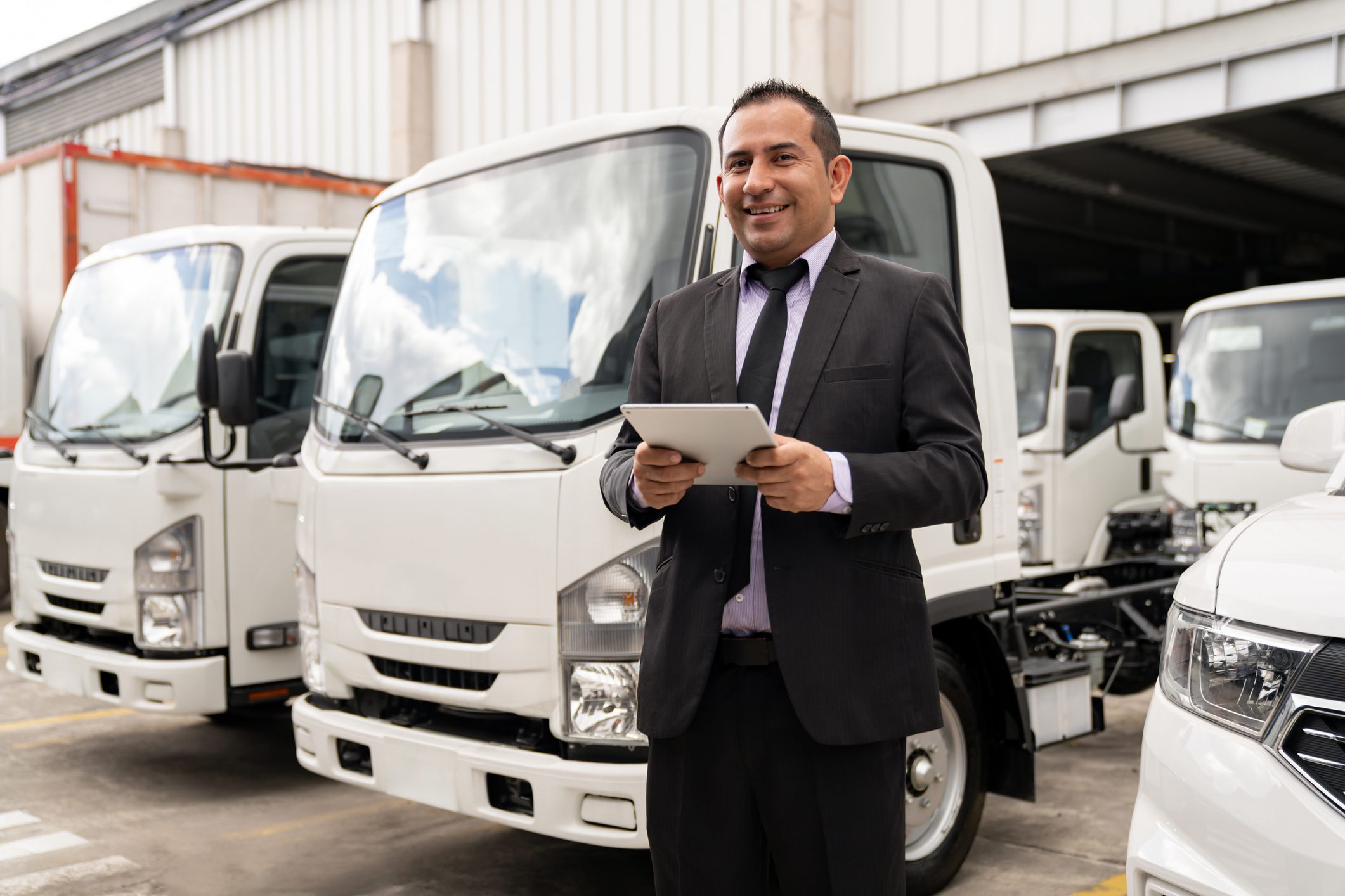 Man with tablet standing near trucks